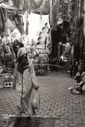 Image du Maroc Professionnelle de  Une femme marocaine traditionnellement vêtue passe par le centre du Souk des Teinturiers, appelé souk Sebbaghine, l'un des plus pittoresque de Marrakech situé dans la Médina, non loin de la source Mouassine, où quelques petits ateliers pratiquent encore de nos jours la teinture traditionnelle. Ce lieu très prisé des touristes et amateurs photos qui désire ardemment des images extrêmement colorées. Avec le temps il est devenu presque une des attractions touristique qui vaut le détour, le 8 Décembre 2018. (Photo / Abdeljalil Bounhar)